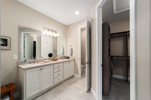 bathroom with toilet, tile patterned floors, and vanity