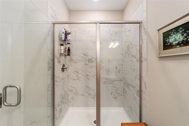 bathroom with a shower with door