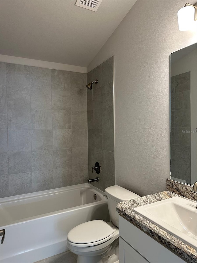 full bathroom with vanity, toilet, lofted ceiling, and tiled shower / bath combo