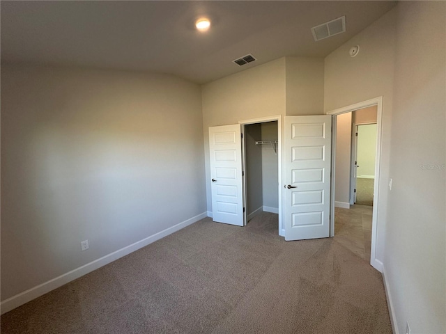 unfurnished bedroom featuring a closet and light colored carpet