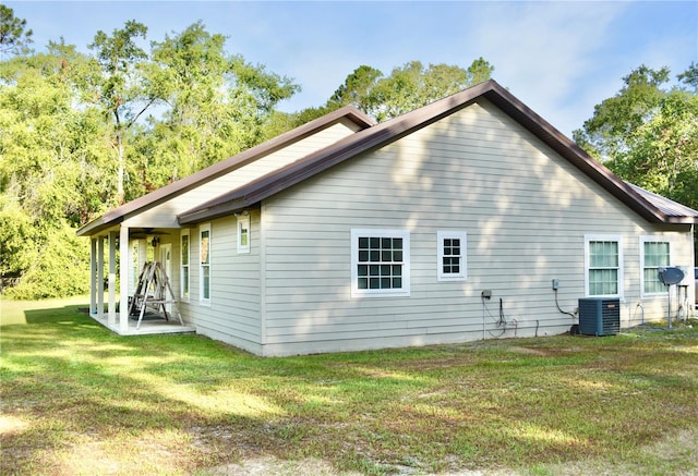 view of property exterior with a patio area, a yard, and central air condition unit