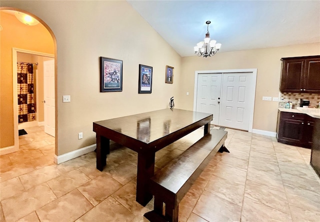 dining space with lofted ceiling and a notable chandelier