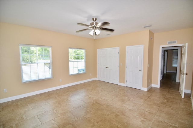 unfurnished bedroom with multiple closets and ceiling fan