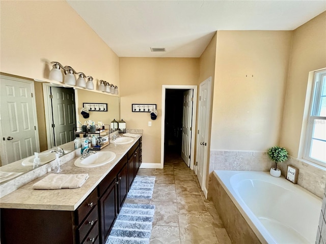 bathroom with vanity and a relaxing tiled tub