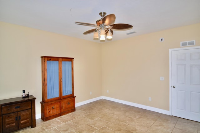 spare room featuring ceiling fan and light tile patterned floors