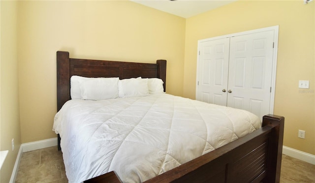 bedroom with tile patterned flooring and a closet