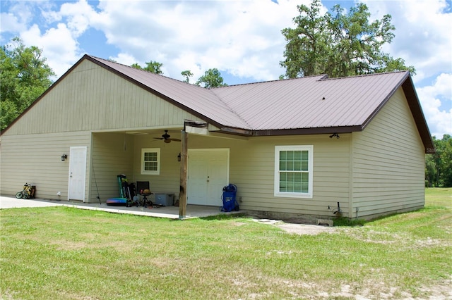 rear view of property with a lawn, ceiling fan, and a patio