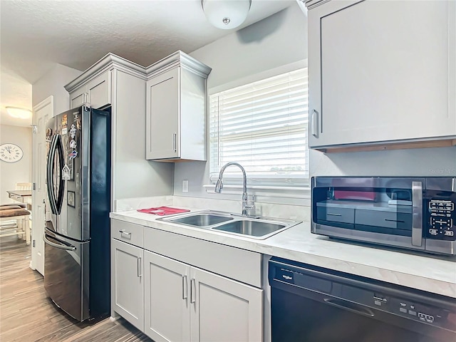 kitchen with sink, black appliances, and light wood-type flooring