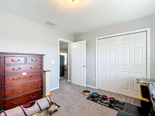 carpeted bedroom with black fridge, a textured ceiling, and a closet