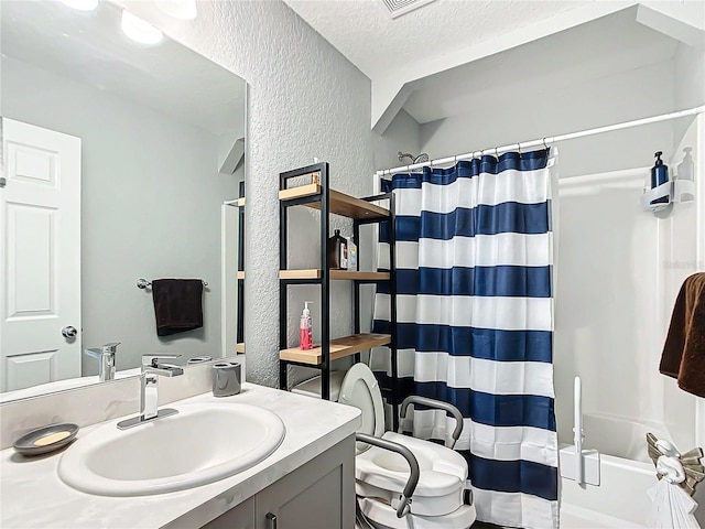 full bathroom with vanity, toilet, shower / tub combo, and a textured ceiling