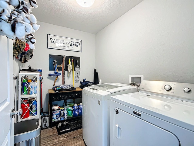 laundry room featuring hardwood / wood-style floors, washing machine and clothes dryer, and a textured ceiling