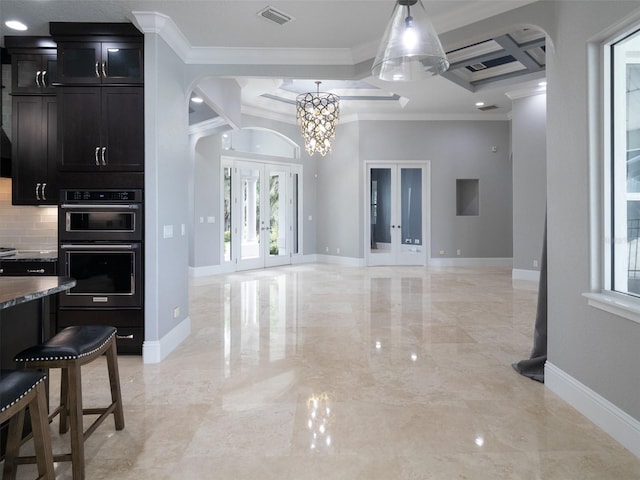 kitchen with black double oven, a kitchen bar, french doors, ornamental molding, and coffered ceiling