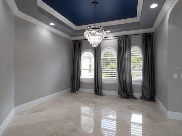 empty room featuring crown molding, an inviting chandelier, and a tray ceiling