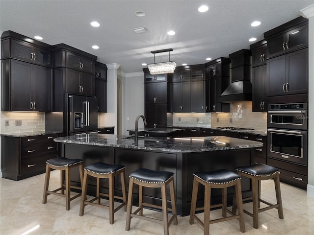 kitchen featuring premium range hood, high end refrigerator, a large island, and multiple ovens