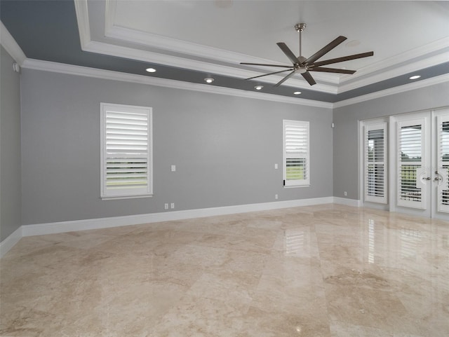 spare room featuring ceiling fan, ornamental molding, and a tray ceiling