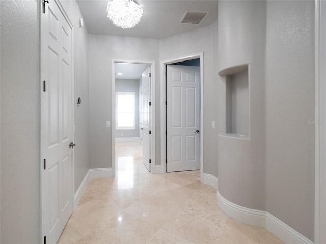 hallway with a notable chandelier