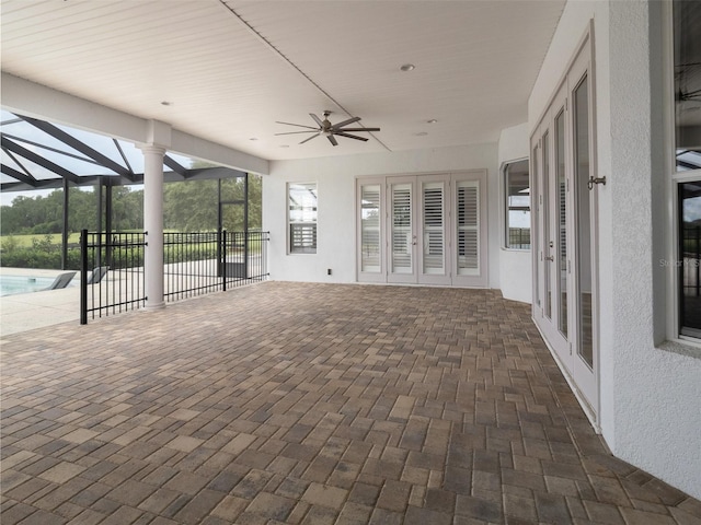 view of patio / terrace featuring ceiling fan and glass enclosure