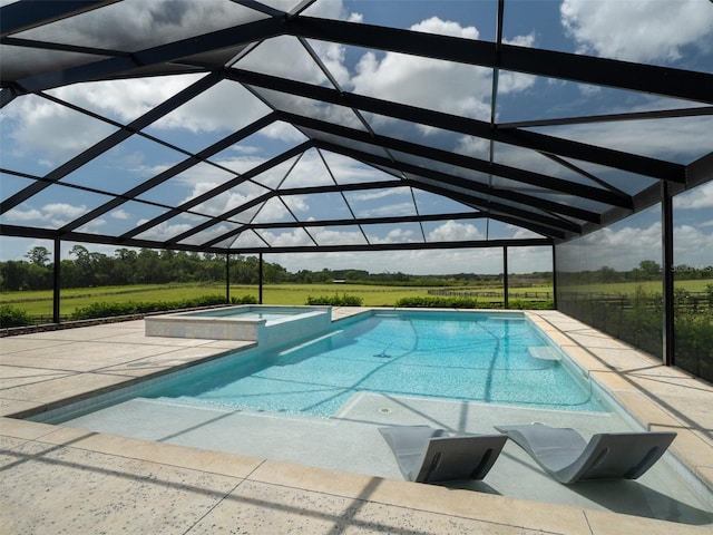 view of swimming pool featuring glass enclosure, an in ground hot tub, and a patio