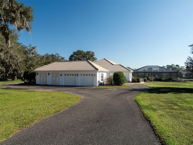 ranch-style house featuring a lanai, a front lawn, and a garage