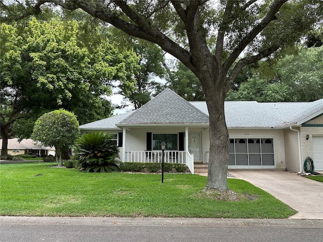 view of front of house with concrete driveway, a front lawn, brick siding, and a garage