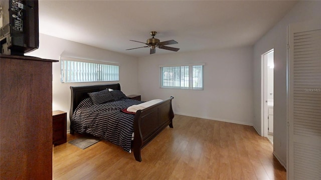 bedroom with light hardwood / wood-style floors, ceiling fan, and ensuite bath