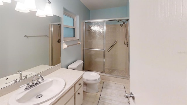 bathroom featuring toilet, vanity, and a stall shower