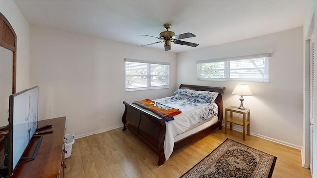 bedroom featuring ceiling fan, baseboards, and light wood-style flooring