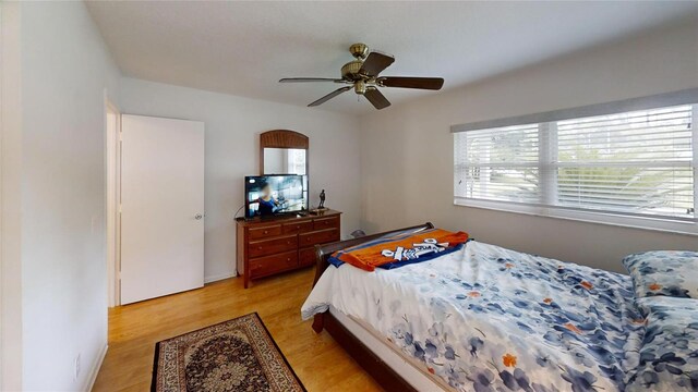 bedroom with a ceiling fan and light wood-style flooring