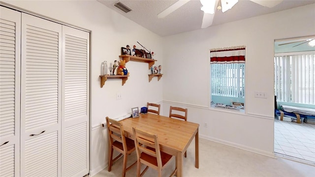 dining area with a ceiling fan, visible vents, and a textured ceiling