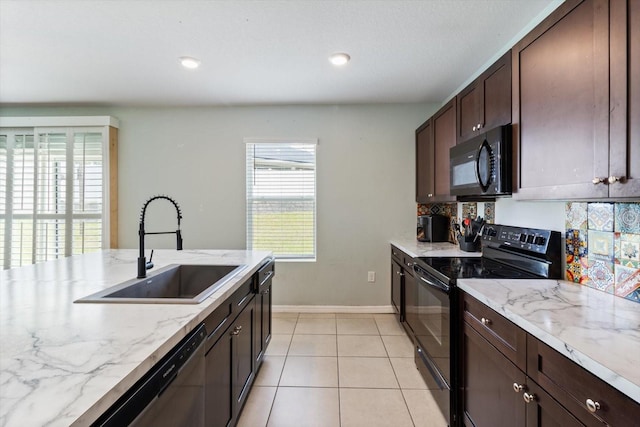 kitchen featuring black appliances, light stone countertops, sink, and light tile patterned flooring