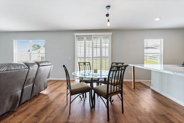 dining area featuring dark wood-type flooring and a wealth of natural light