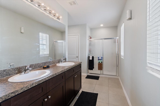 bathroom featuring a shower with shower door, tile patterned floors, and vanity