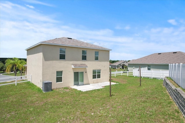 back of property with central AC unit, a patio area, and a yard