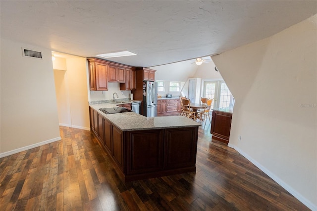 kitchen with kitchen peninsula, stainless steel appliances, ceiling fan, and dark wood-type flooring