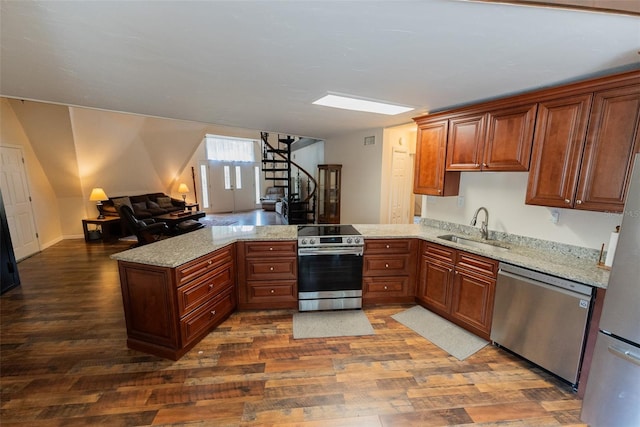 kitchen featuring kitchen peninsula, appliances with stainless steel finishes, light stone counters, sink, and dark hardwood / wood-style floors