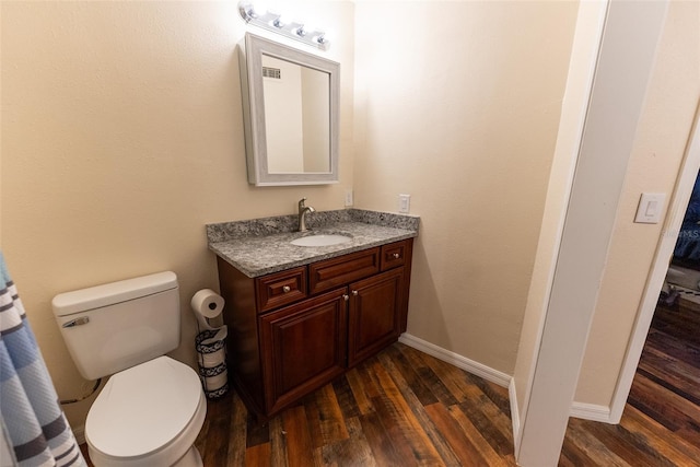 bathroom with hardwood / wood-style flooring, vanity, and toilet