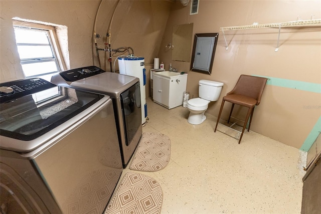 clothes washing area with electric panel, washer and clothes dryer, and water heater