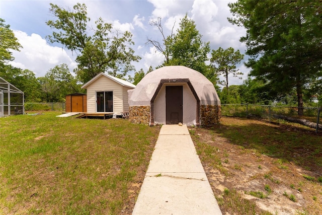 exterior space featuring a storage shed and a front lawn