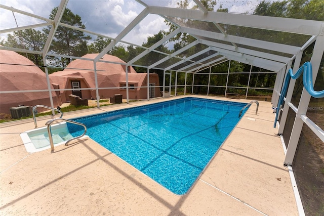 view of swimming pool with glass enclosure, central AC unit, and a patio area