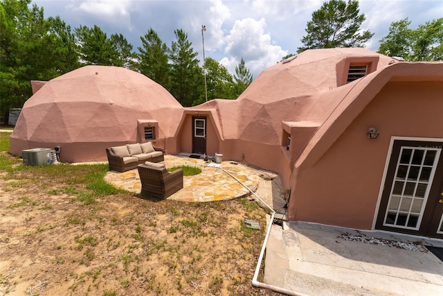 view of yard with an outdoor living space, a patio, and central AC