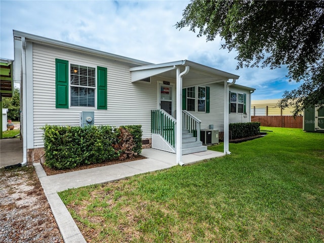 view of front of property featuring central air condition unit and a front lawn