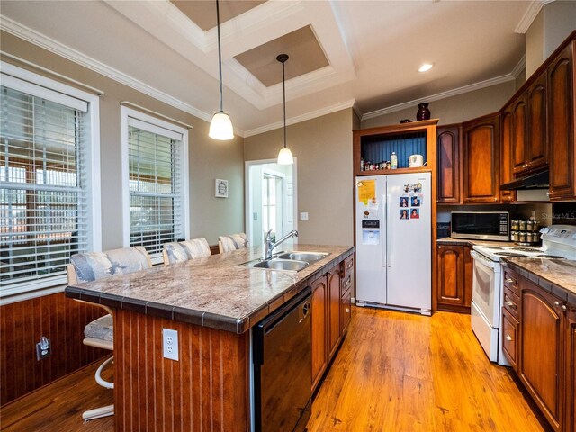 kitchen featuring crown molding, a kitchen breakfast bar, light wood-type flooring, an island with sink, and white appliances