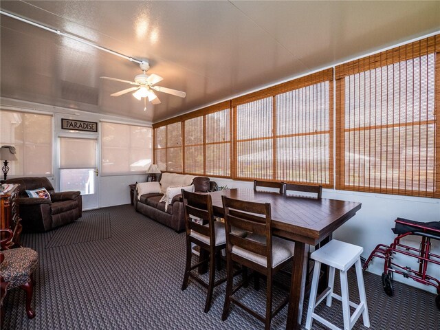 carpeted dining space with ceiling fan