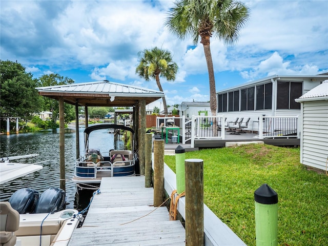 dock area with a lawn and a water view