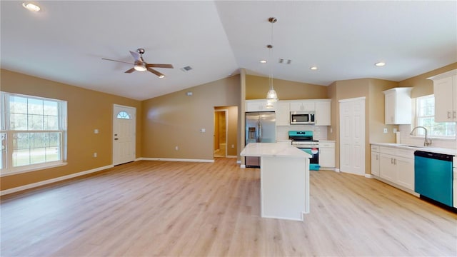 kitchen with pendant lighting, sink, white cabinetry, stainless steel appliances, and a kitchen island