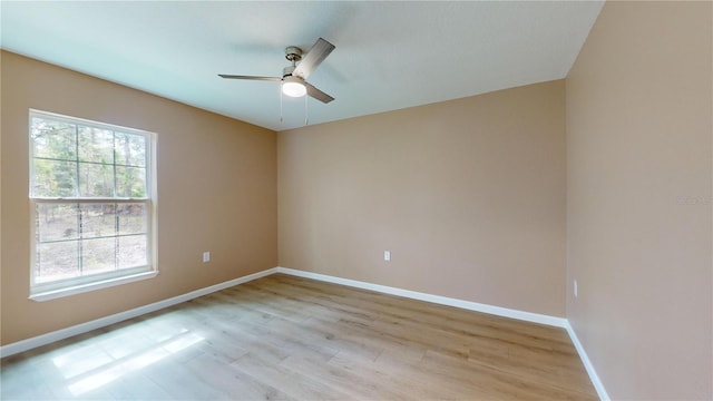 empty room with ceiling fan and light hardwood / wood-style flooring