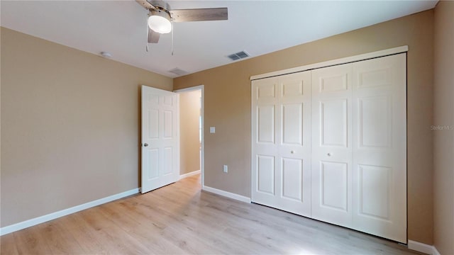 unfurnished bedroom featuring ceiling fan, a closet, and light wood-type flooring