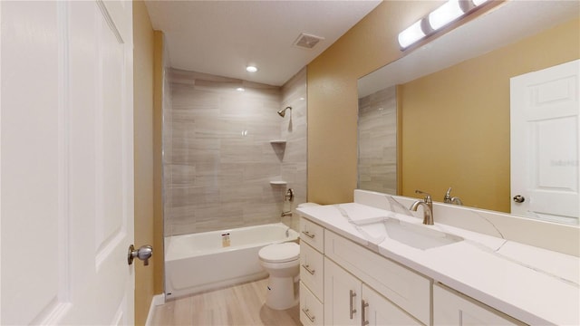 full bathroom featuring tiled shower / bath combo, vanity, wood-type flooring, and toilet