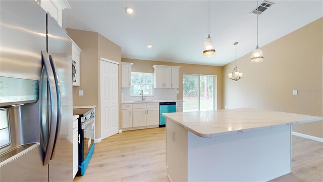 kitchen with pendant lighting, white cabinetry, backsplash, stainless steel appliances, and a kitchen island