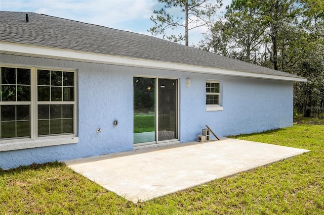 rear view of house with a lawn and a patio